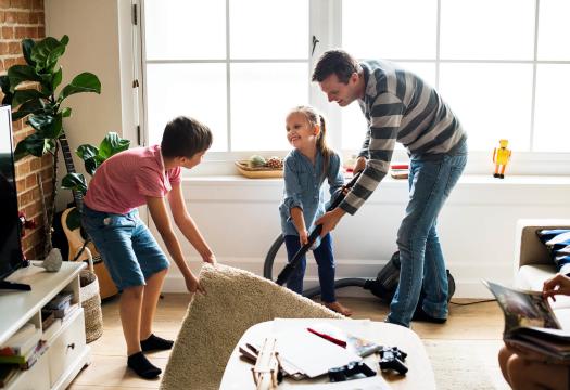 dad daughter and son vacuuming rug