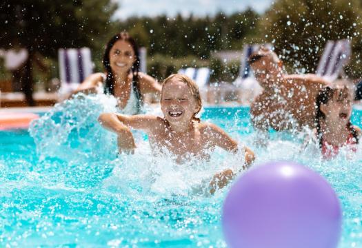 Young child playing in a pool with mom and sister | Merry Maids
