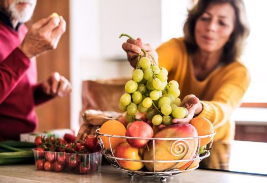Couple eating fruit in kitchen