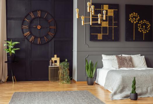 Dark bedroom interior with fresh plants, carpet on floors, double bed, and gold lamp | Merry Maids