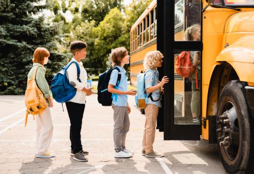 Kids waiting in line to get on a school buss | Merry Maids